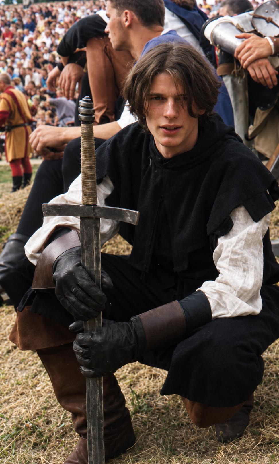 Kneeling in reenactment armour with a longsword at a historical festival
